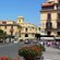 Pedestrians exploring the town of Sorrento on a street lined with flowers, trees and charming architecture.
